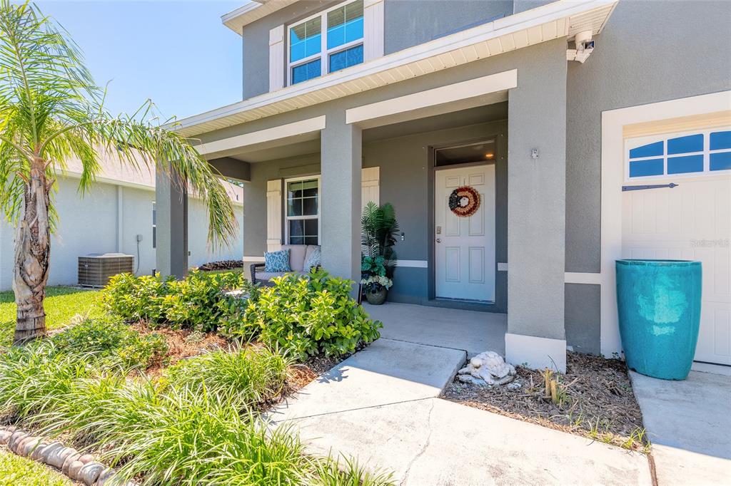 The exterior of a two-story house features a covered front porch, landscaping, and a garage — 319 SUNSET VIEW DRIVE, EDGEWATER, FL