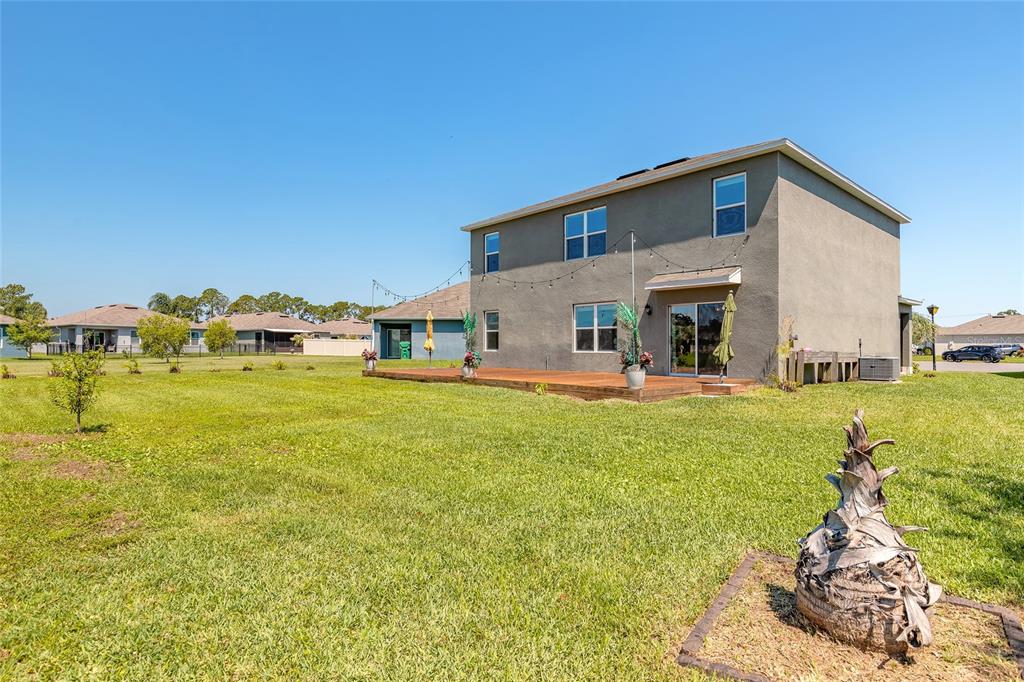 The exterior of a two-story house features a wooden deck and a large grassy yard — 319 SUNSET VIEW DRIVE, EDGEWATER, FL