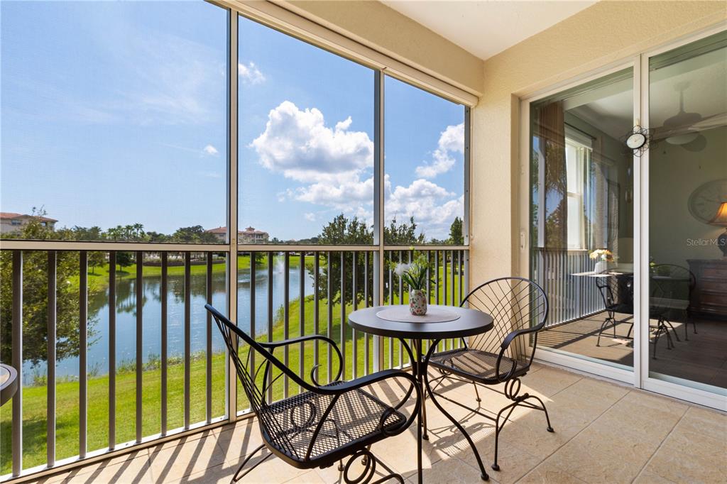 A screened-in balcony features a small bistro table and chairs overlooking a pond — 75 RIVERVIEW BEND S UNIT 1624, PALM COAST, FL