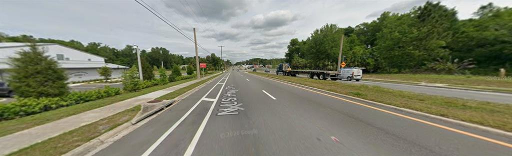 A view of a multi-lane road with a sidewalk and trees on a cloudy day — 18011 N US HWY 301, CITRA, FL