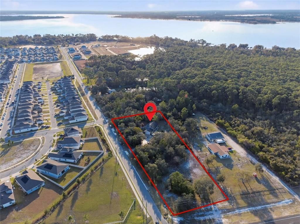 An aerial view shows a house on a large, wooded lot outlined in red — 6365 WHIP O WILL LANE, ST CLOUD, FL
