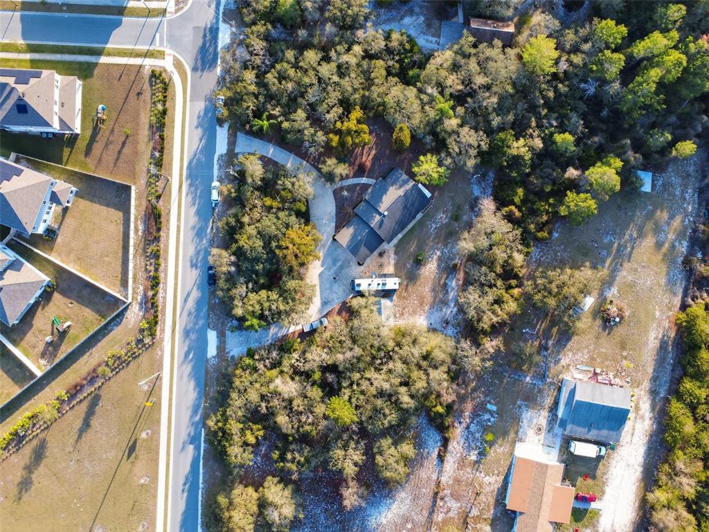 An aerial view shows a house with a driveway and RV parked on a wooded lot — 6365 WHIP O WILL LANE, ST CLOUD, FL