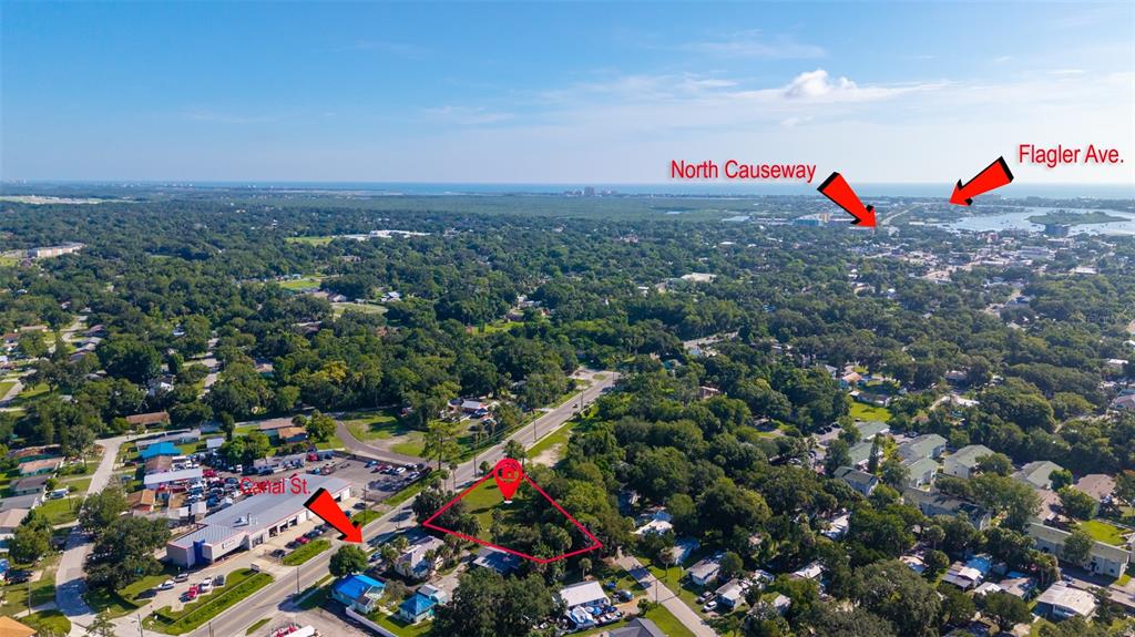 This aerial view shows a vacant lot highlighted in red within a residential neighborhood — 1104 CANAL STREET, NEW SMYRNA BEACH, FL