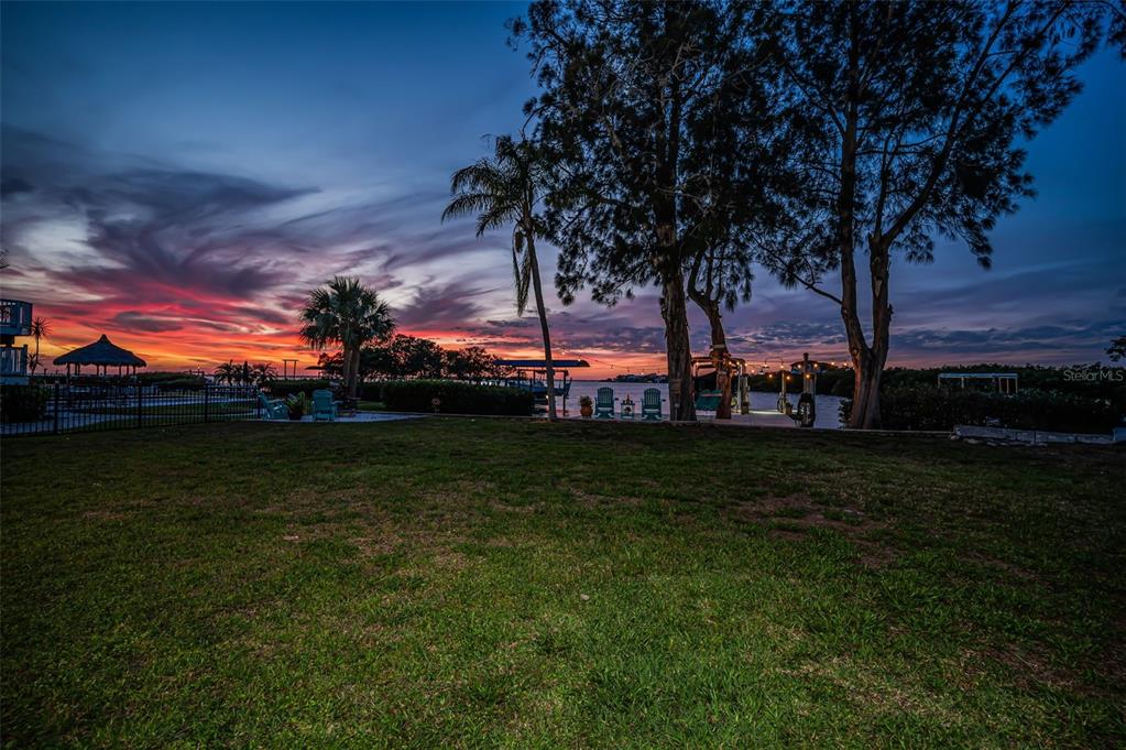 An aerial view shows a residential peninsula surrounded by water with docks and mangrove areas — 1626 SEA BREEZE DRIVE, TARPON SPRINGS, FL