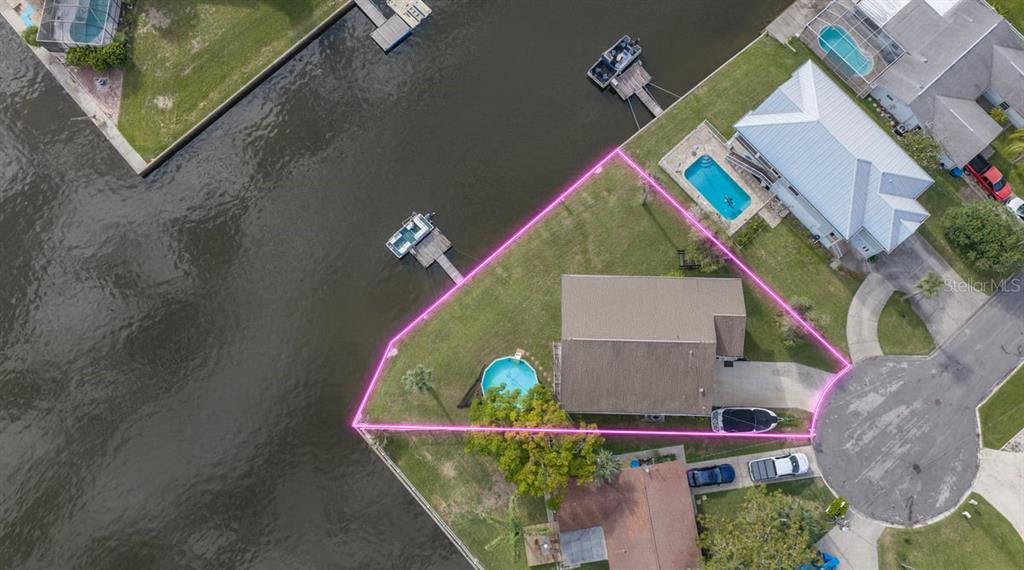 A two-story house with a driveway and an inset photo showing a backyard pool and canal — 4514 NEPTUNE DRIVE, HERNANDO BEACH, FL