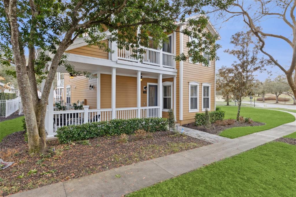 A two-story yellow house with a covered front porch and a white railing — 7494 GATHERING DRIVE, REUNION, FL