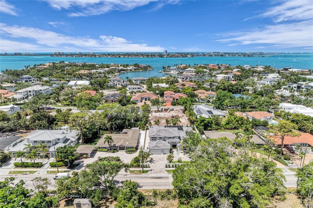 An aerial view shows a residential neighborhood with a modern house near a coastal bay — 1395 HARBOR DRIVE, SARASOTA, FL