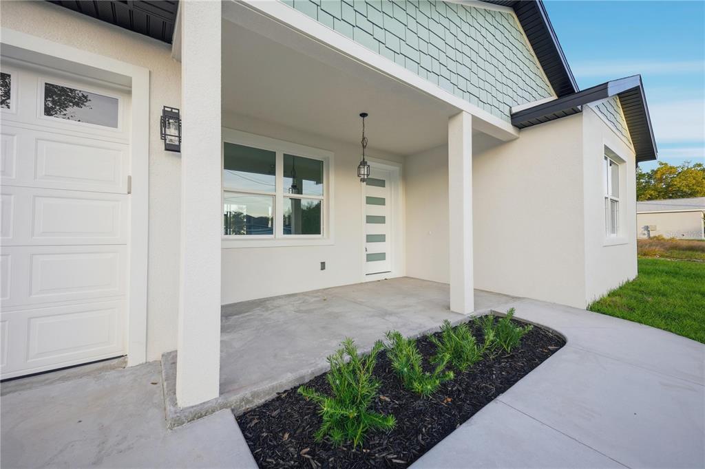 A single-story house with a white stucco exterior and a concrete driveway sits on grass — 12414 SE 106TH COURT, BELLEVIEW, FL