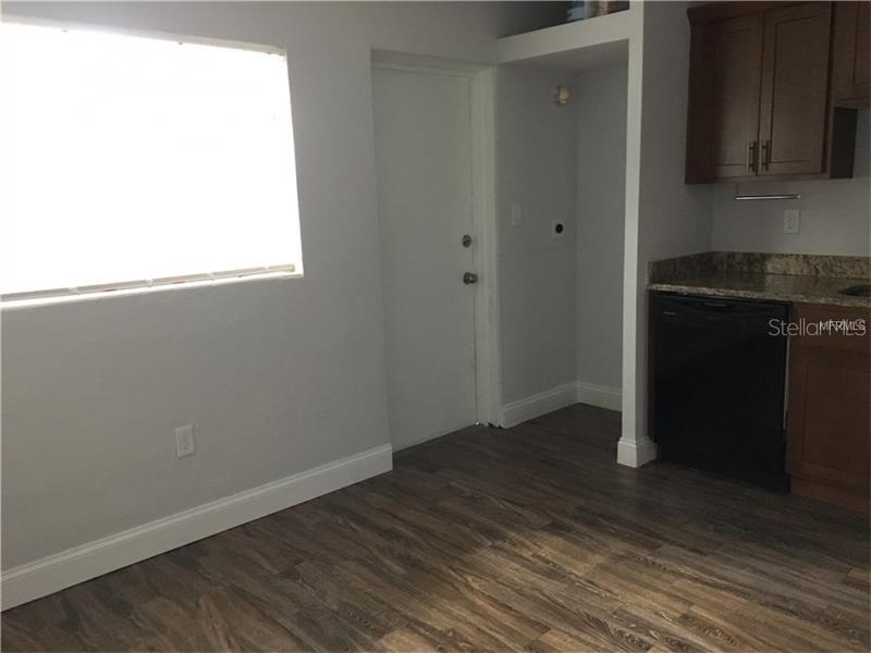 A kitchen area features wood-look flooring, dark cabinets, a black dishwasher, and a white door — 508 VARSITY STREET, WINTER GARDEN, FL