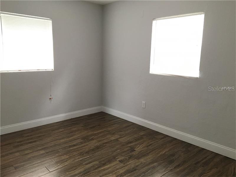 An empty bedroom features gray walls, white trim, and dark wood-look flooring — 508 VARSITY STREET, WINTER GARDEN, FL