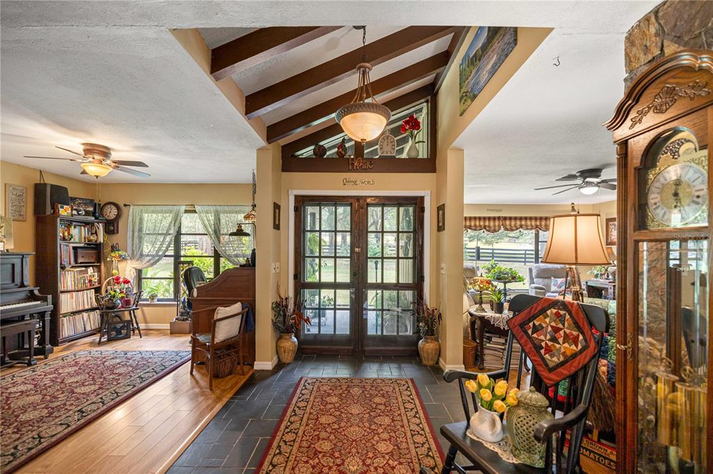 An entryway with a slate floor, vaulted wood-beamed ceiling, and double glass doors — 4556 E VIEW TOP LANE, INVERNESS, FL