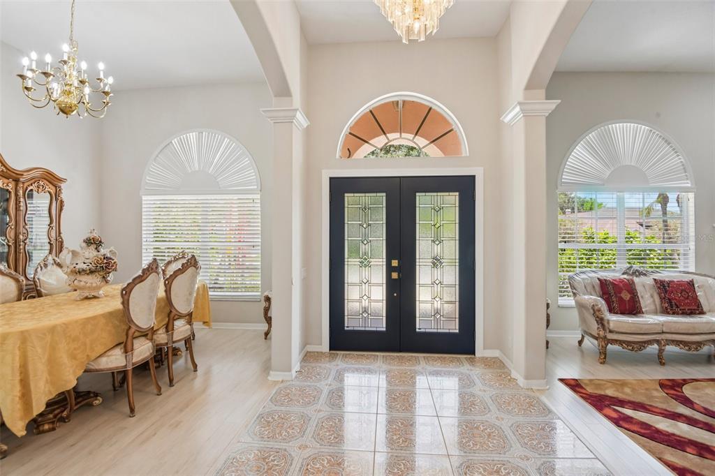 An entryway with tiled floors leads to a dark double door with glass panels — 1701 COUNTRY TRAILS DRIVE, SAFETY HARBOR, FL