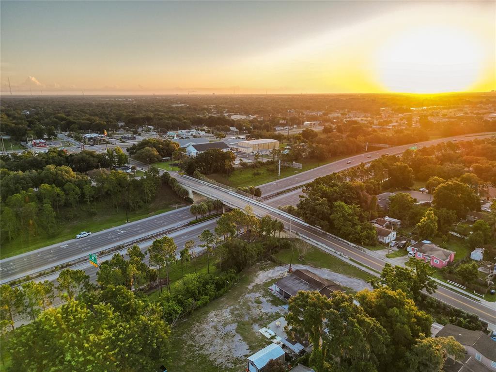 An aerial view shows a highway overpass crossing a multi-lane road at sunset — 6114 W AMELIA STREET, ORLANDO, FL