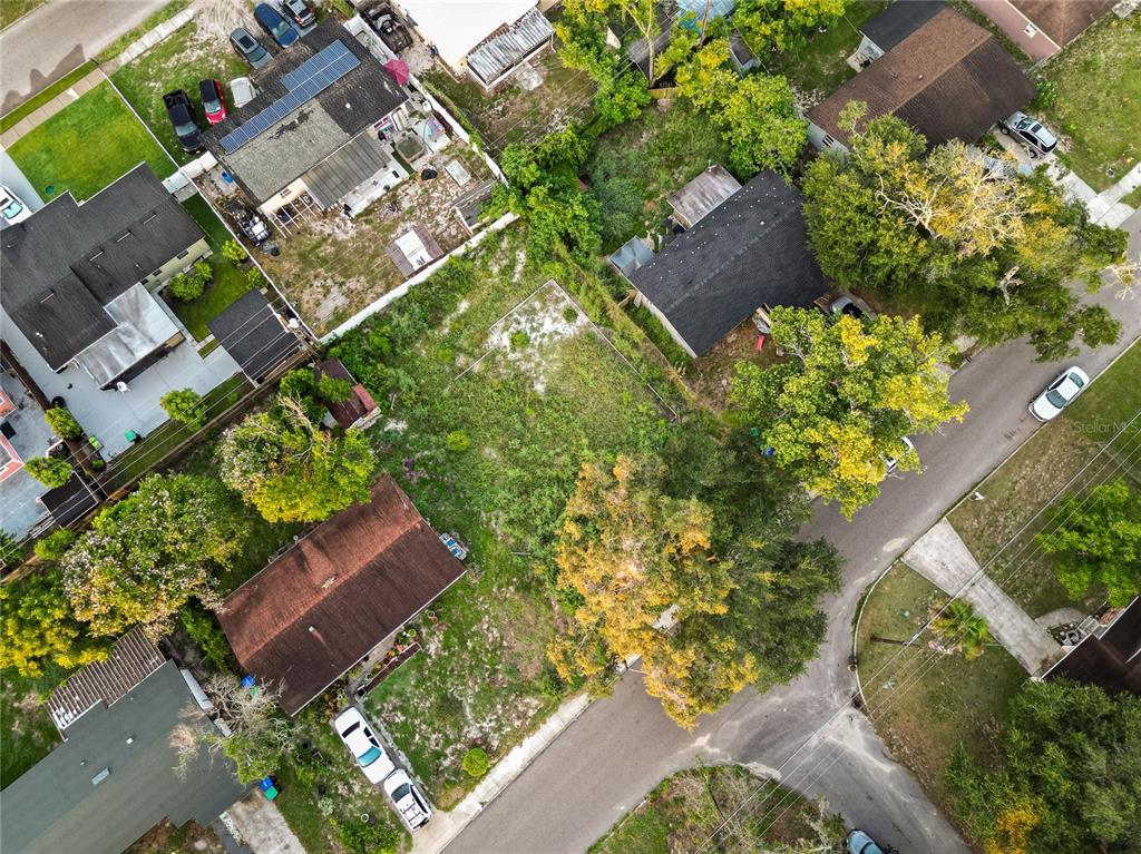 An aerial view shows a vacant residential lot situated between several houses and a street — 6114 W AMELIA STREET, ORLANDO, FL