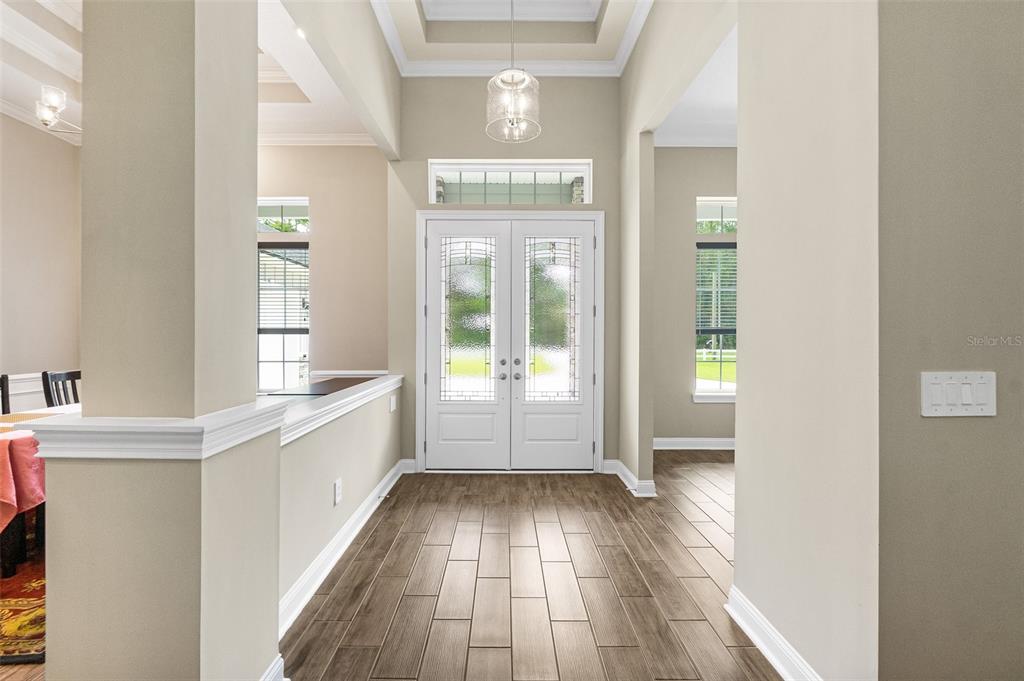 An entryway with wood-look tile flooring, double front doors, and a tray ceiling — 2505 CABBAGE HAMMOCK ROAD, ST AUGUSTINE, FL