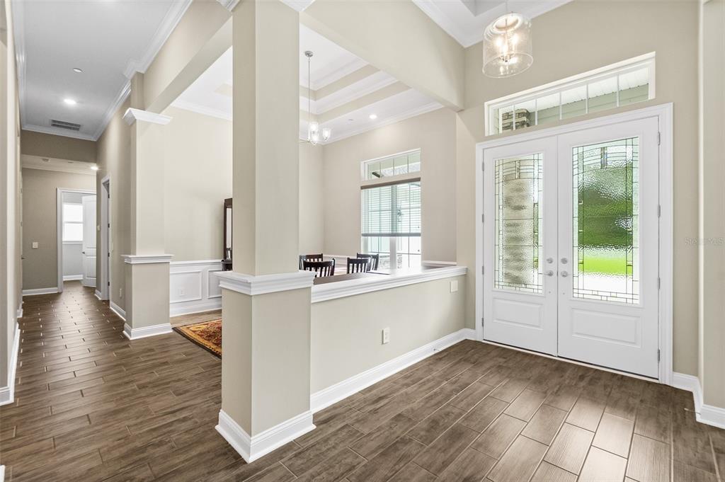 An entryway features wood-look tile flooring, a half wall, and double glass-paneled front doors — 2505 CABBAGE HAMMOCK ROAD, ST AUGUSTINE, FL