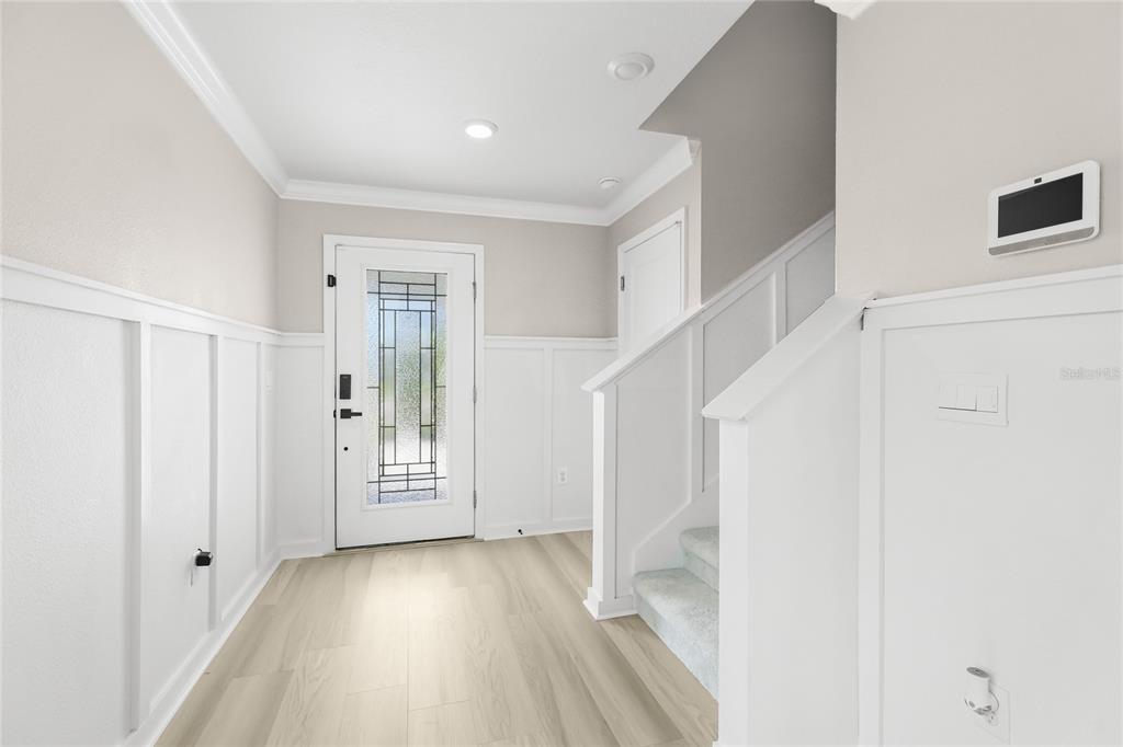 A white stucco house features a covered front porch with a dark-framed glass front door — 12272 HIGH ROCK WAY, PARRISH, FL