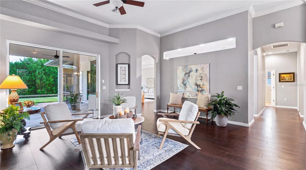 A living room features light gray walls, dark wood floors, and sliding glass doors to outside — 16203 33RD COURT E, PARRISH, FL