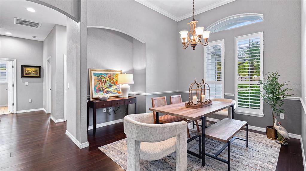 A dining room features a wooden table, upholstered chairs, a bench, and a console table — 16203 33RD COURT E, PARRISH, FL