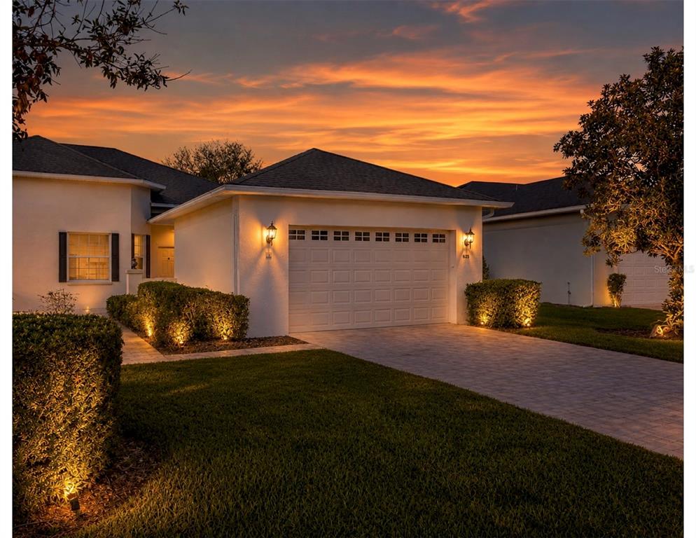A paved walkway leads to a recessed front door with a lantern light fixture — 1018 GREEN GATE BOULEVARD, GROVELAND, FL