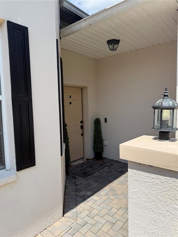 A kitchen features light-colored cabinets, dark granite countertops, stainless steel appliances, and two bar stools — 1018 GREEN GATE BOULEVARD, GROVELAND, FL