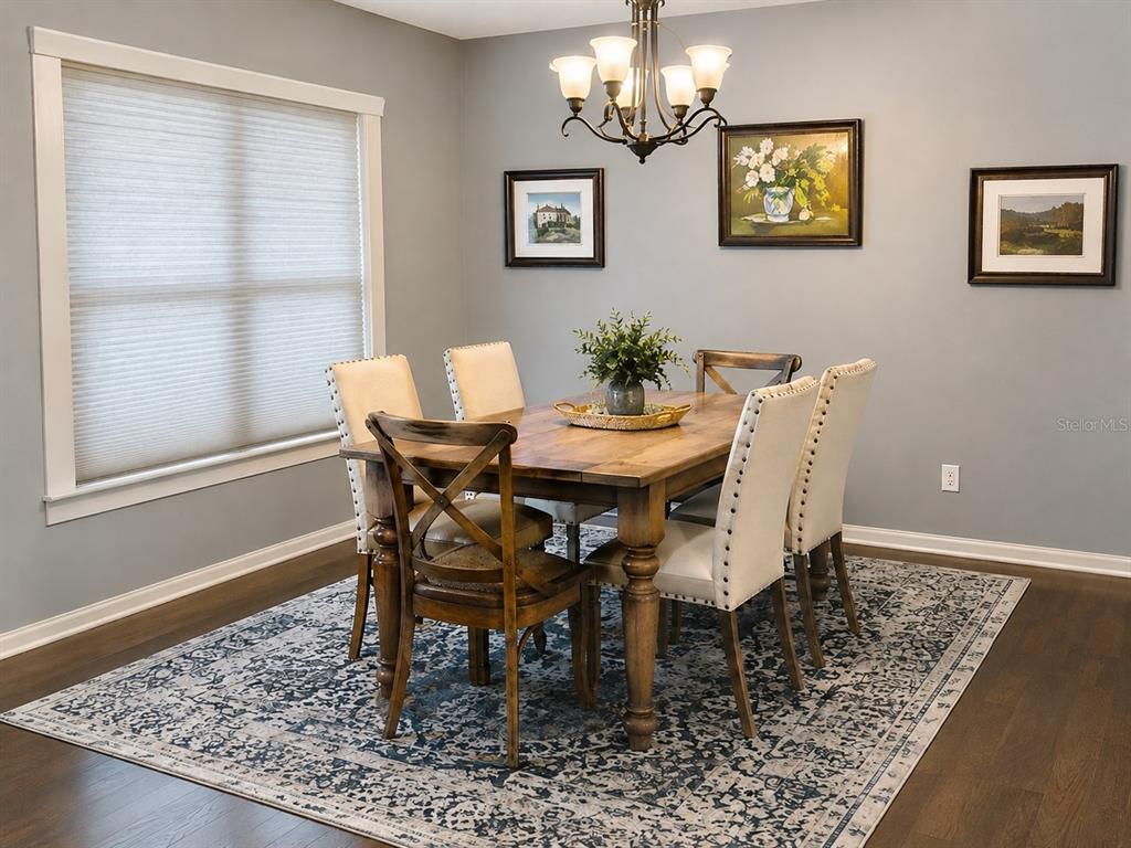 A living room features a fireplace, light blue leather sofas, and dark wood flooring — 4704 RIVER RIDGE DRIVE, LEESBURG, FL