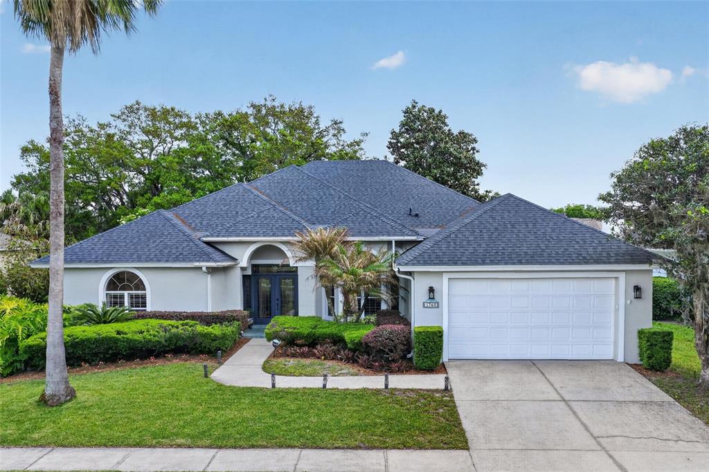 A single-story house with a gray exterior, a dark shingled roof, and a two-car garage — 1760 EDGEWATER DRIVE, MOUNT DORA, FL
