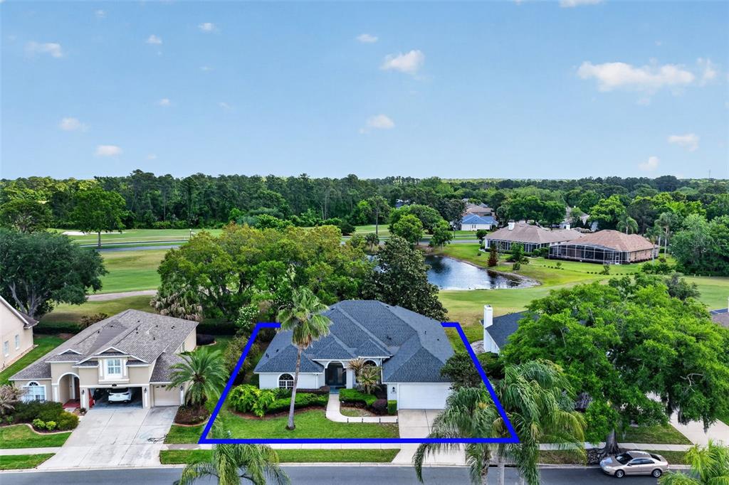 An aerial view of a single-story house with a dark roof and a front lawn — 1760 EDGEWATER DRIVE, MOUNT DORA, FL