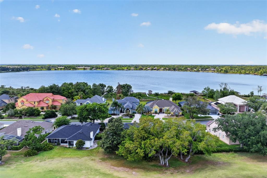 An aerial view shows several houses situated along the shore of a large lake — 1760 EDGEWATER DRIVE, MOUNT DORA, FL