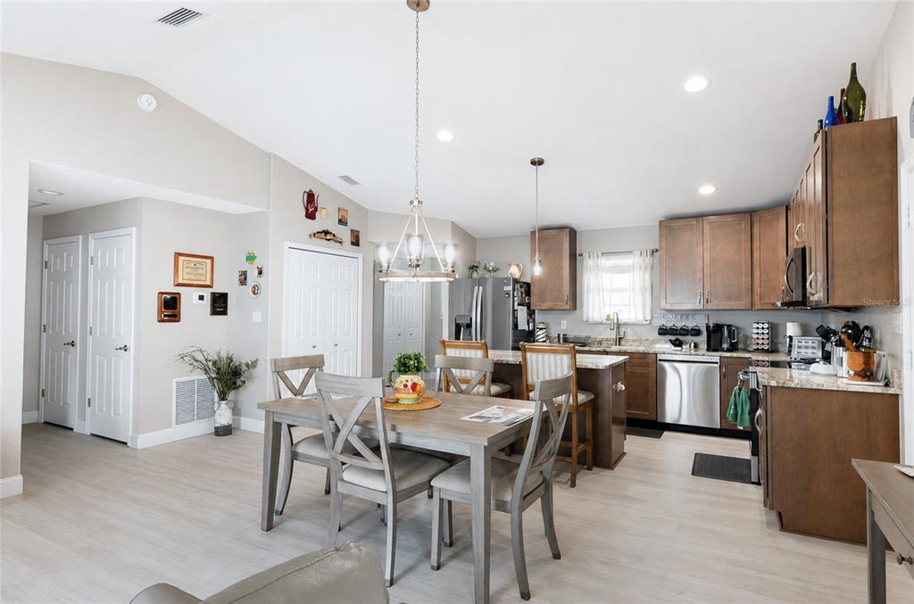 A dining area with a wooden table and chairs sits adjacent to an open kitchen — 615 FOURTH, BUNNELL, FL