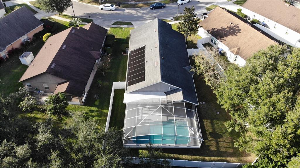 An aerial view shows a house with a solar-paneled roof and a screened-in pool — 457 MICKLETON LOOP, OCOEE, FL