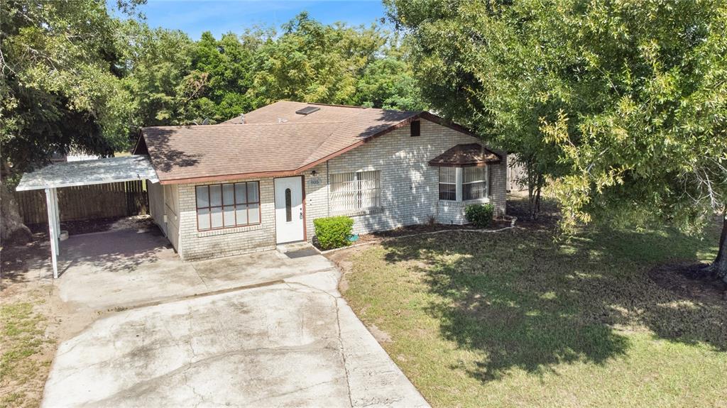 A single-story brick house with a brown shingled roof, carport, and concrete driveway — 805 CENTER STREET, DUNDEE, FL