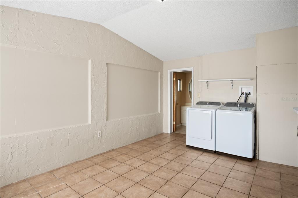 A laundry room with tile flooring, white appliances, and two recessed wall panels — 805 CENTER STREET, DUNDEE, FL