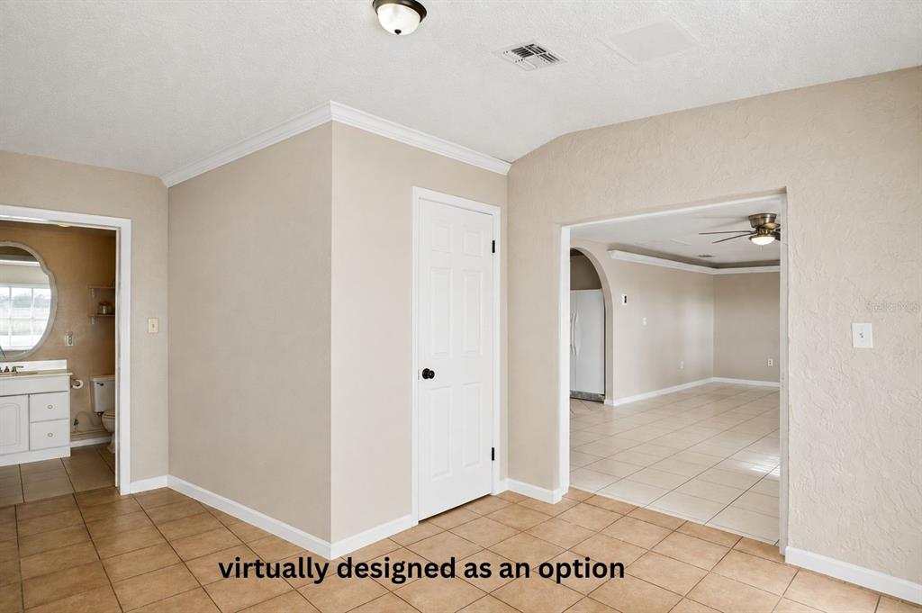 A room with tan walls, tiled floors, a white door, and an arched entryway — 805 CENTER STREET, DUNDEE, FL