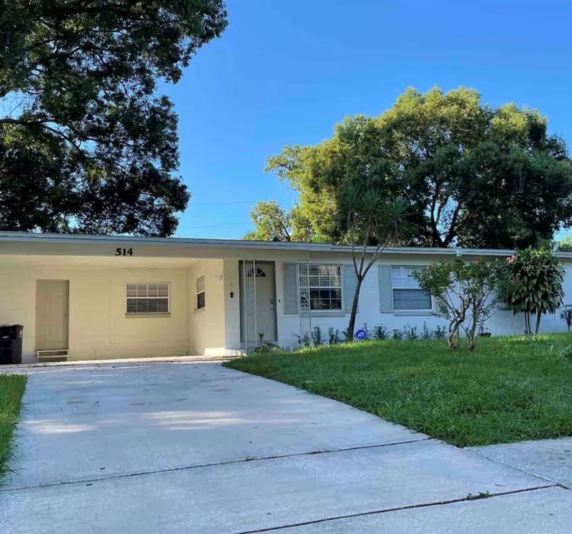 A single-story house with a white exterior, a concrete driveway, and a covered carport — 514 WIGMAN DRIVE, MAITLAND, FL