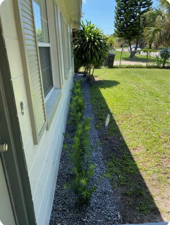A side view of a house exterior featuring a gravel garden bed with small shrubs — 514 WIGMAN DRIVE, MAITLAND, FL