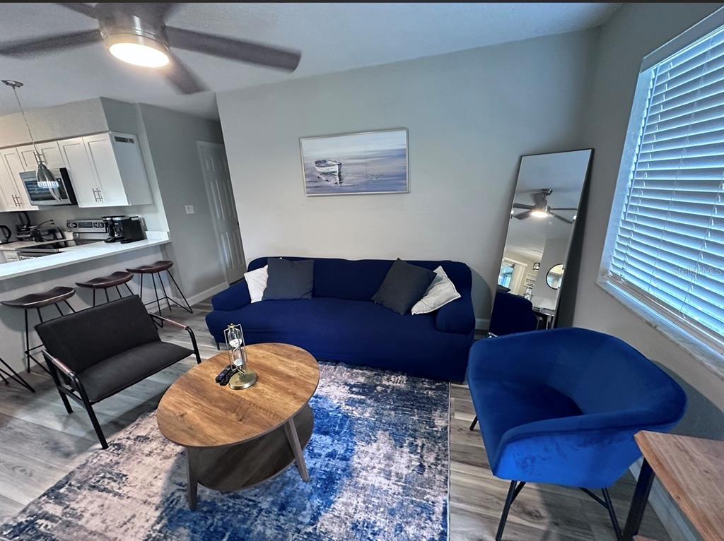 A living room features a blue sofa, a round wooden coffee table, and a blue chair — 514 WIGMAN DRIVE, MAITLAND, FL