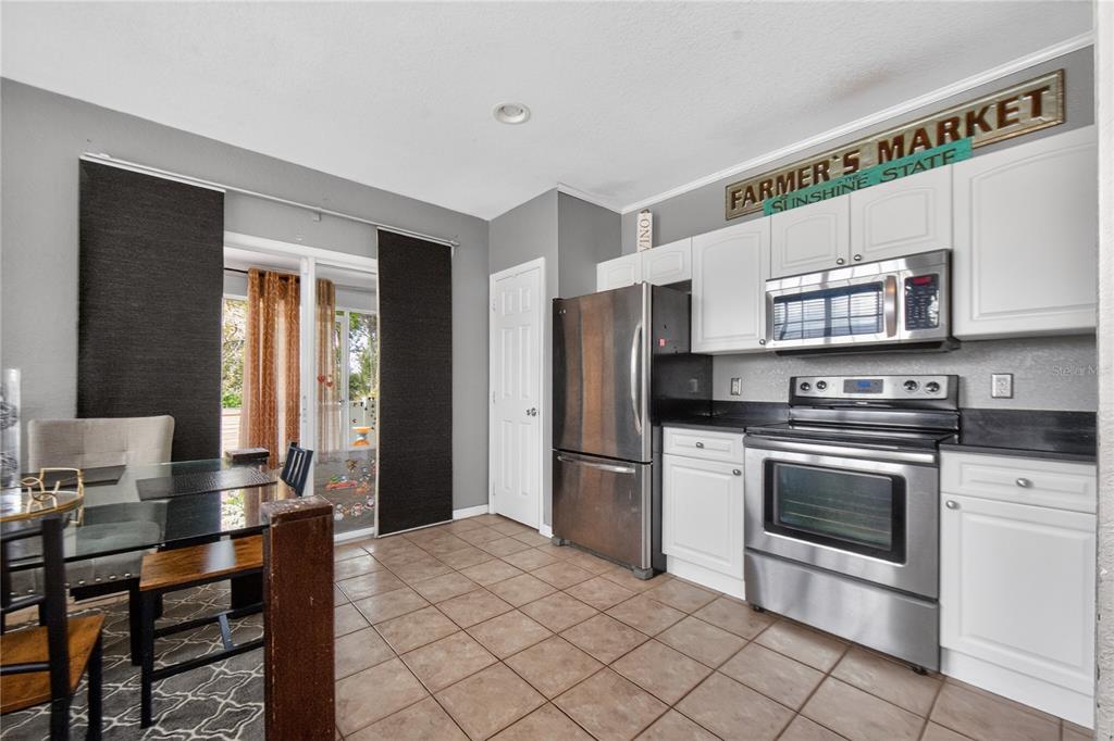 A kitchen features white cabinets, a double-basin sink, and red walls over tiled flooring — 4204 PLANTATION COVE DRIVE, ORLANDO, FL