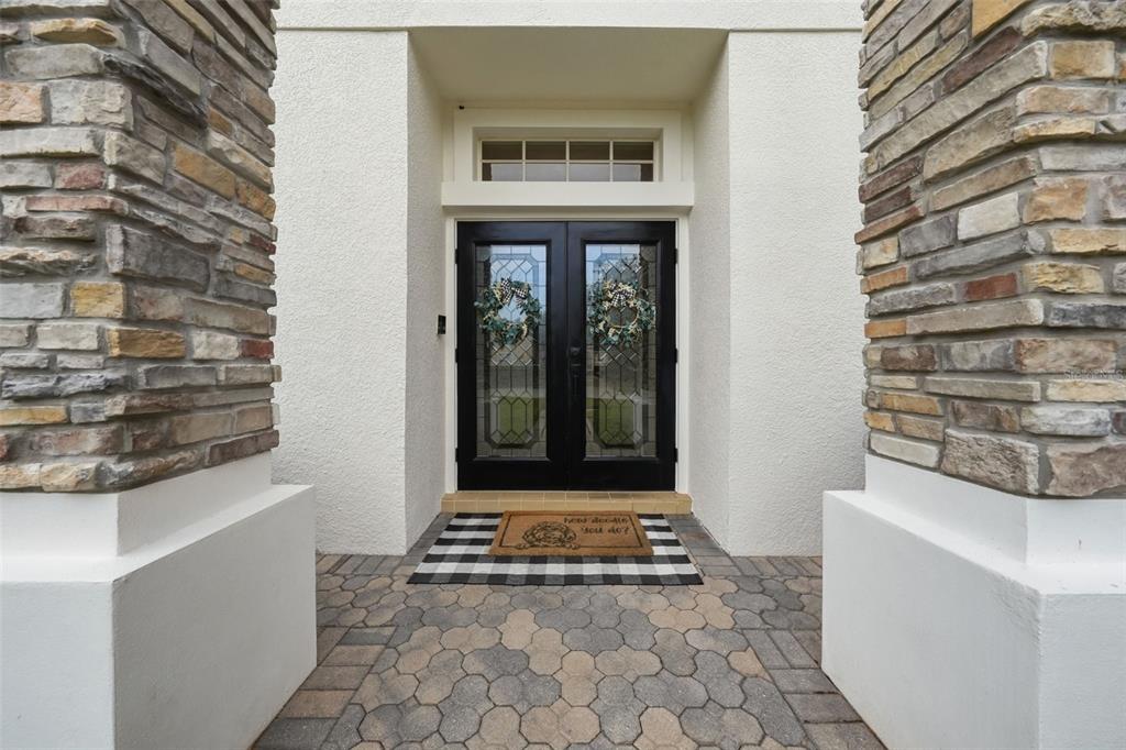 A front entryway features double glass doors, stone columns, and a patterned rug on pavers — 3930 OLD DUNN RD, APOPKA, FL