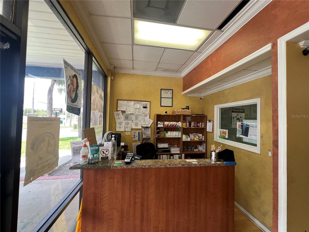 A reception desk with a wood-grain front sits in a small office with yellow walls — 1810 STATE ROAD 436, WINTER PARK, FL