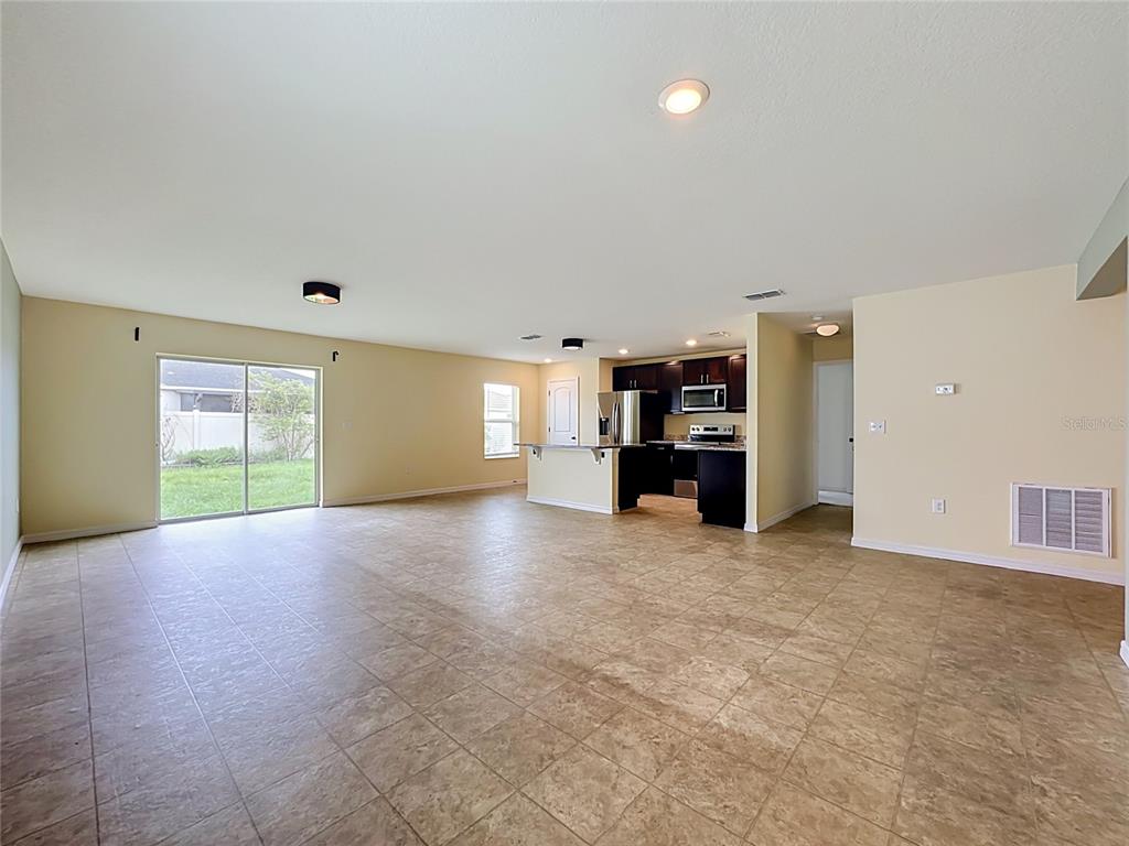 A bedroom features a wooden bed frame, a dresser, a ceiling fan, and a window — 10624 MASSIMO DRIVE, WIMAUMA, FL