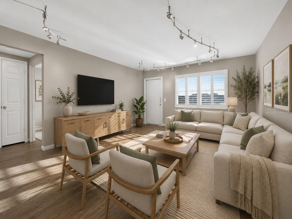 An empty room features wood-look tile flooring, gray walls, a white door, and track lighting — 6015 19TH STREET N UNIT 215, ST PETERSBURG, FL