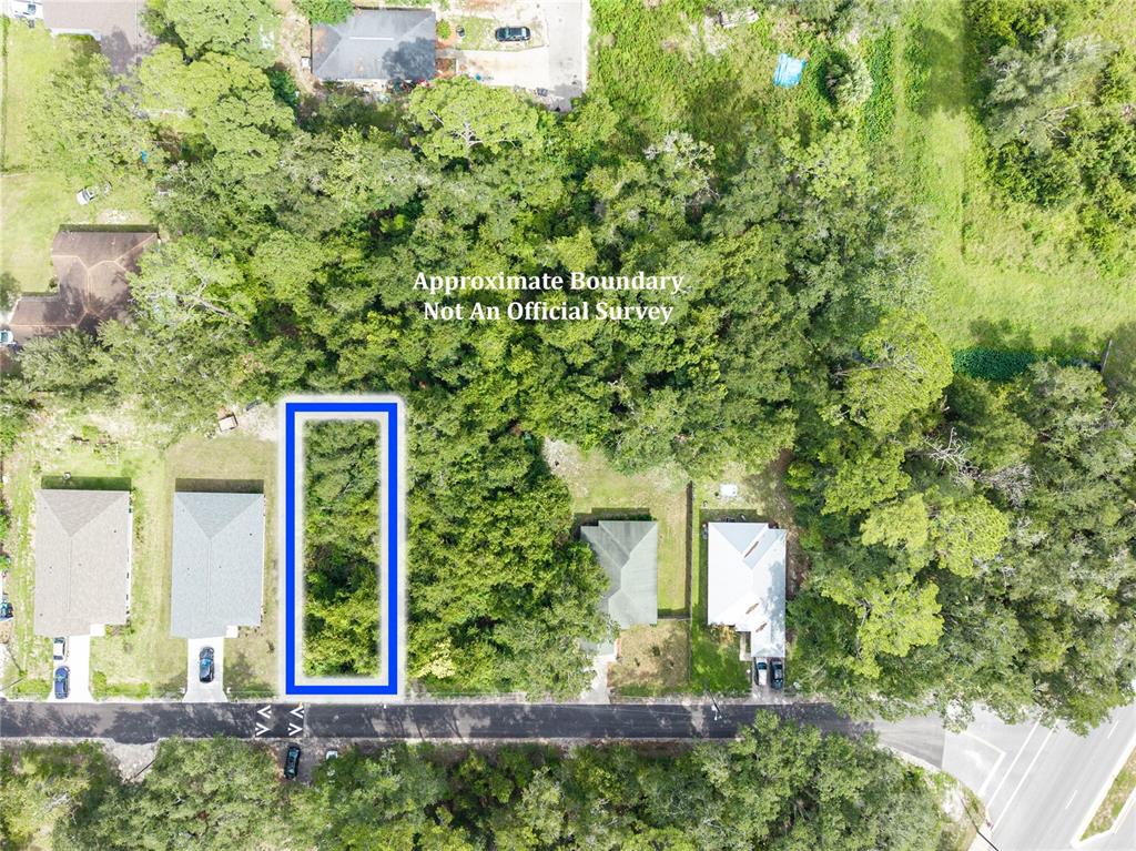 An aerial view shows a vacant, rectangular lot outlined in blue between two residential houses — 319 SE 20TH STREET, GAINESVILLE, FL