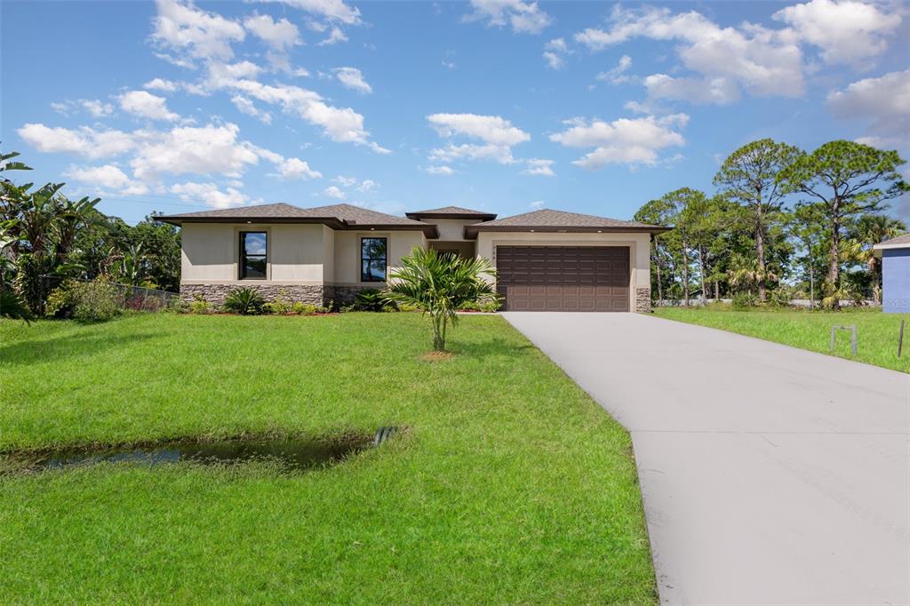 A single-story house with a brown garage door, stone accents, and a concrete driveway — 900 LAVA STREET SE, PALM BAY, FL