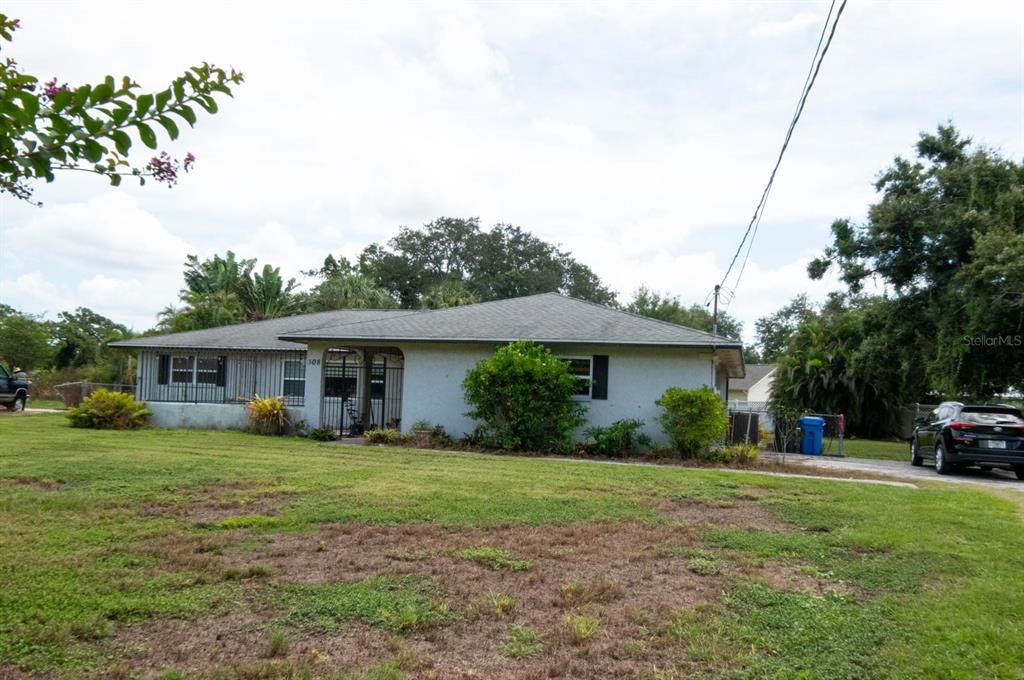 A single-story house with a gray exterior, a hip roof, and a front porch — 308 WENDI LANE, RUSKIN, FL