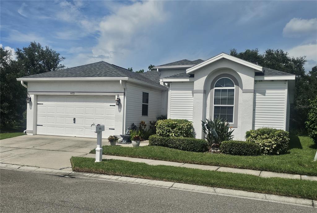 A single-story house with a white exterior, a two-car garage, and a large arched window — 603 CANAL WAY, OLDSMAR, FL