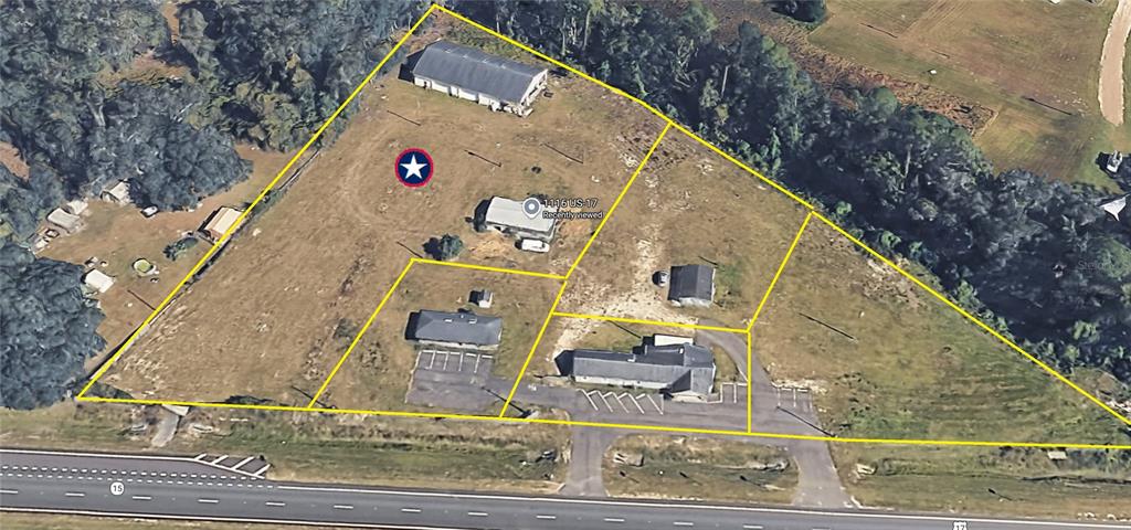 An aerial view shows several buildings on a large, grassy lot adjacent to a highway — 1116 N HIGHWAY 17 UNIT 1, PALATKA, FL
