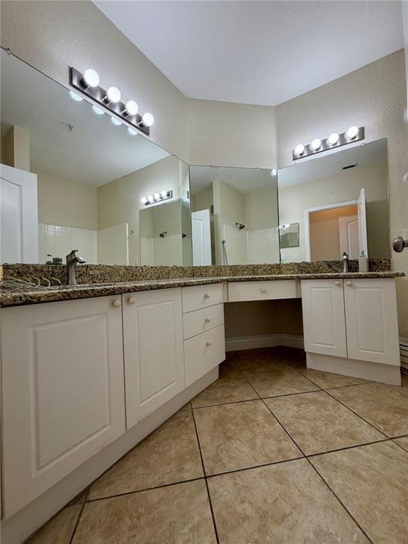 A bathroom vanity with white cabinets, granite countertops, and large mirrors — 2724 VIA MURANO UNIT 622, CLEARWATER, FL