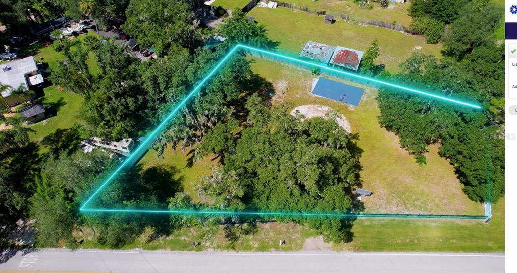 An aerial view shows a large, tree-filled residential lot outlined in glowing blue lines — 1550 S TANNER ROAD, ORLANDO, FL
