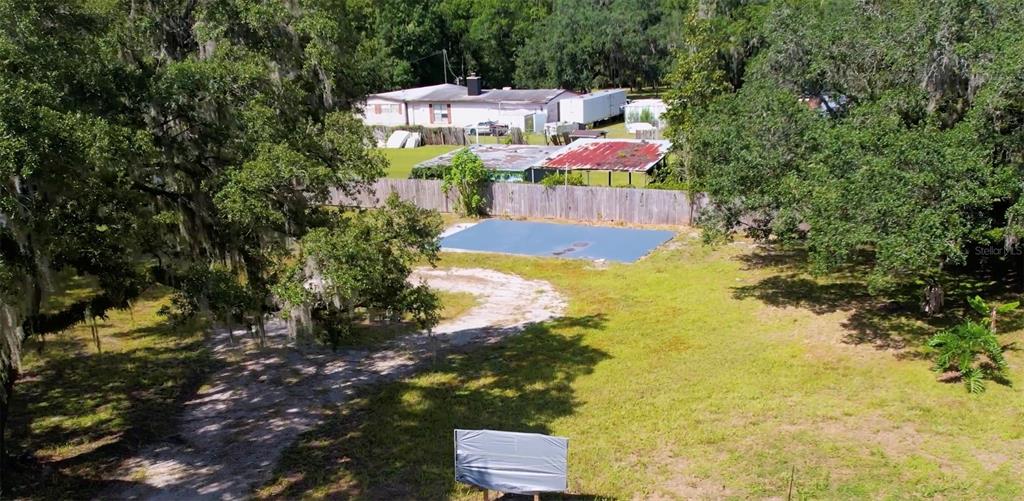 An aerial view of a grassy lot featuring a concrete slab and a wooden fence — 1550 S TANNER ROAD, ORLANDO, FL